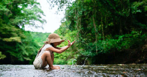 Girl playing in a mountain stream