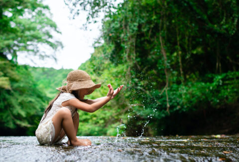 Girl playing in a mountain stream