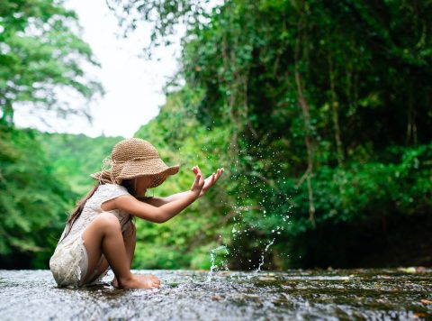 Girl playing in a mountain stream