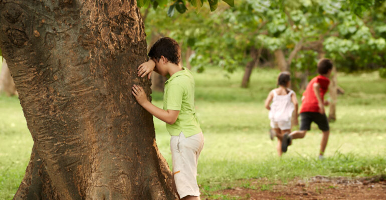 male and female children playing hide and seek