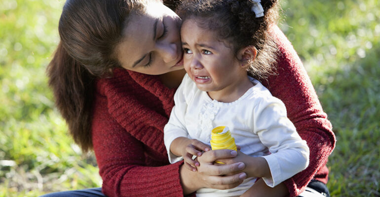 Hispanic mother comforting crying daughter